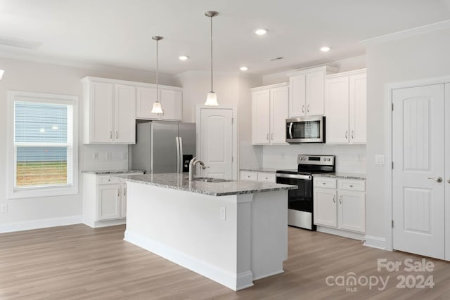 kitchen featuring an island with sink, white cabinets, appliances with stainless steel finishes, and sink