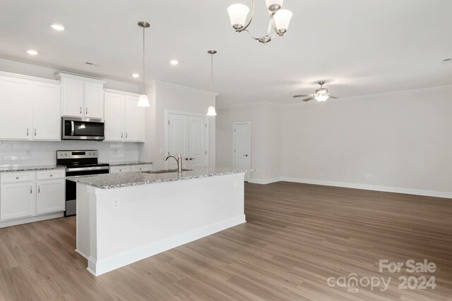 kitchen featuring ceiling fan with notable chandelier, white cabinets, a kitchen island with sink, and appliances with stainless steel finishes