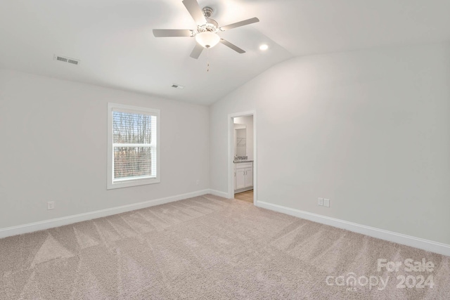 unfurnished room featuring ceiling fan, light colored carpet, and vaulted ceiling