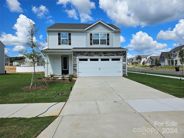 front of property with a garage and a front lawn