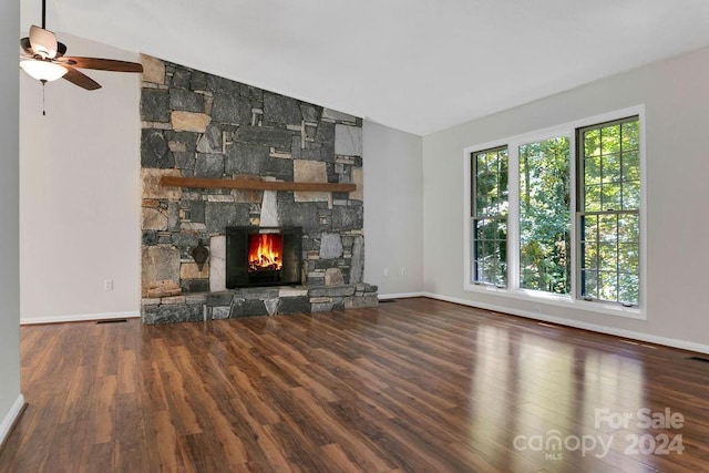 unfurnished living room featuring a wealth of natural light, lofted ceiling, and a stone fireplace