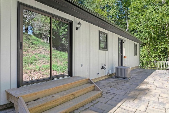 view of exterior entry with cooling unit and a patio area