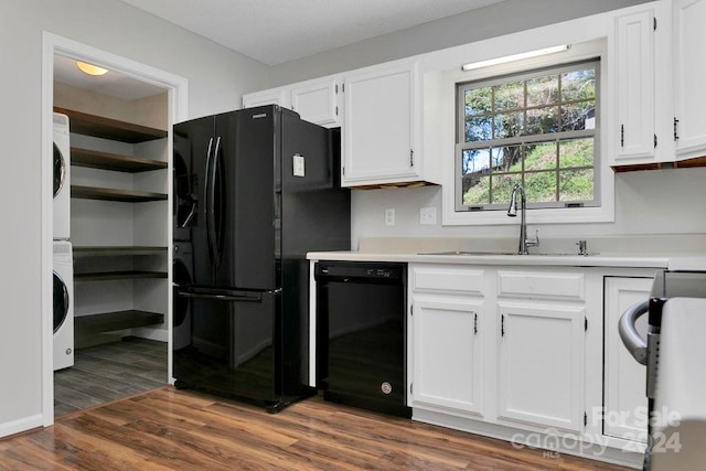 kitchen featuring black appliances, stacked washer and dryer, white cabinetry, and dark hardwood / wood-style flooring