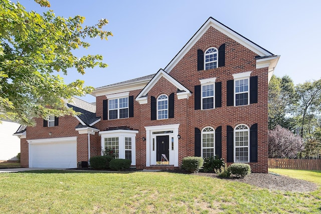 colonial home with a front yard and a garage