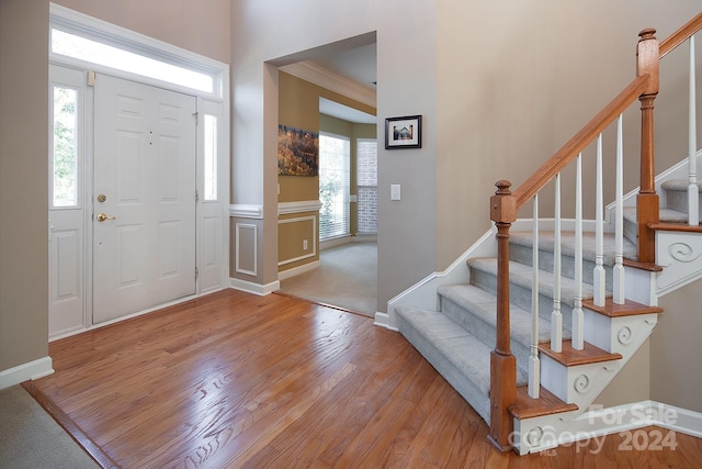 foyer with ornamental molding and light hardwood / wood-style flooring