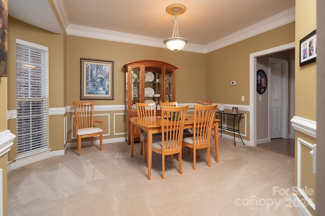 carpeted dining area featuring crown molding