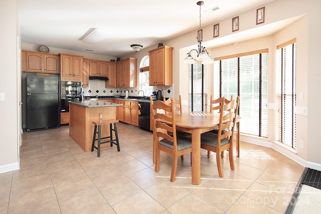 kitchen with decorative backsplash, a kitchen island, hanging light fixtures, sink, and black appliances