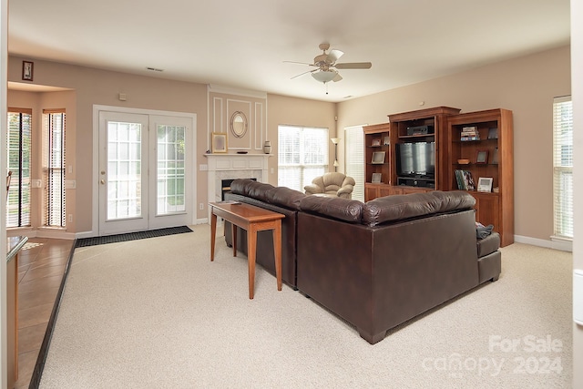 carpeted living room with ceiling fan, a healthy amount of sunlight, and a large fireplace