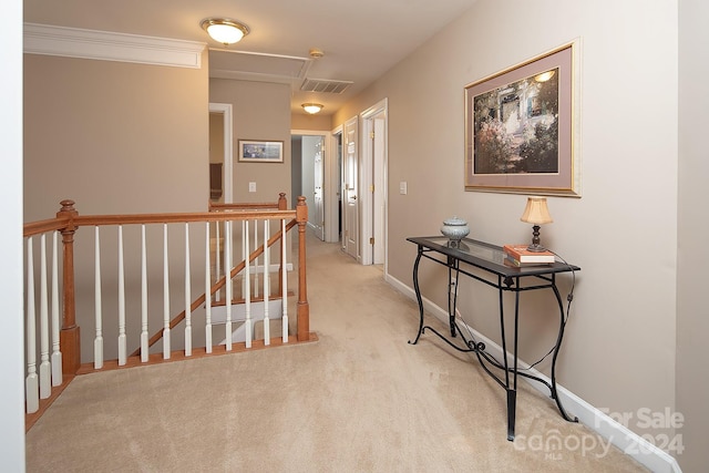 corridor featuring ornamental molding and light colored carpet