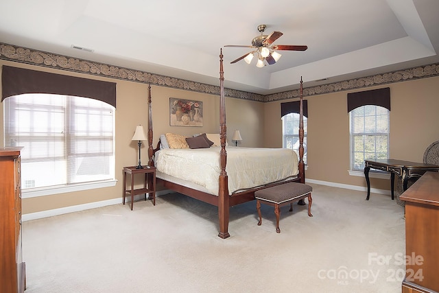 bedroom with carpet, ceiling fan, and a raised ceiling