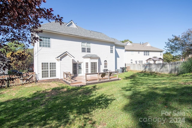 back of house with a wooden deck, central AC, and a lawn