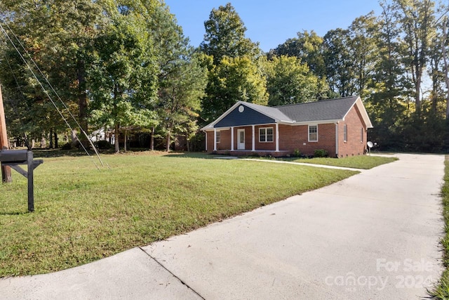 ranch-style home featuring covered porch and a front yard