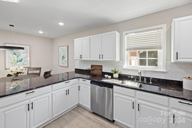 kitchen with dishwasher, sink, white cabinets, backsplash, and dark stone countertops