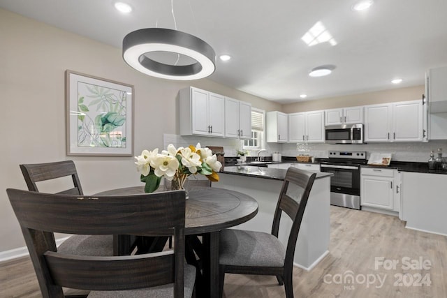 dining space featuring light wood-type flooring and sink