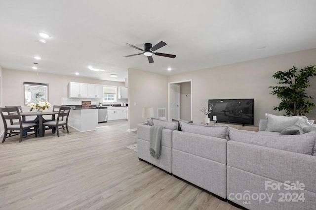 living room with light hardwood / wood-style floors and ceiling fan