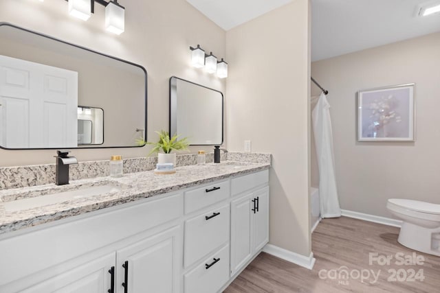 full bathroom with wood-type flooring, vanity, toilet, and shower / bath combination with curtain