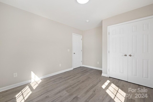 unfurnished bedroom featuring a closet and hardwood / wood-style flooring