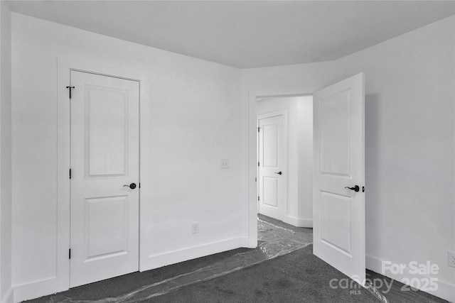 unfurnished bedroom with dark colored carpet