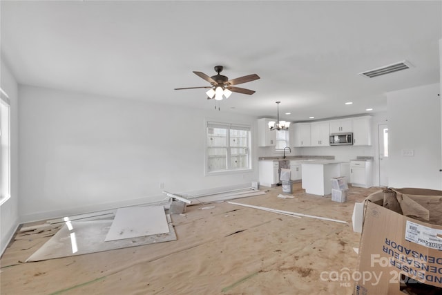 unfurnished living room with ceiling fan with notable chandelier and sink