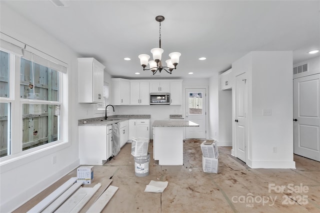 kitchen with a kitchen island, pendant lighting, sink, white cabinets, and stainless steel appliances