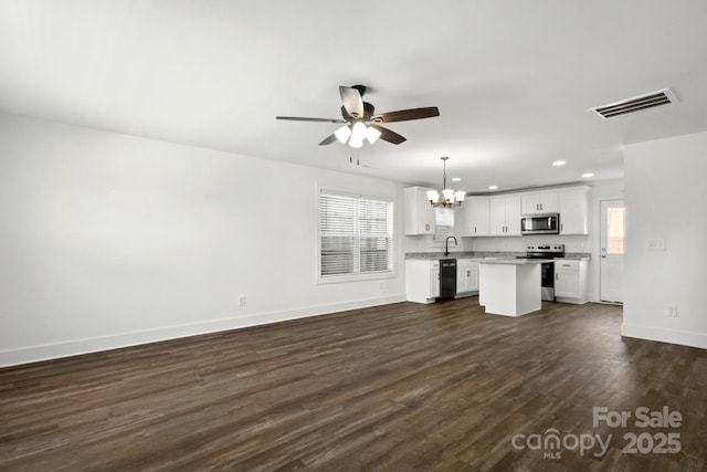 unfurnished living room with ceiling fan with notable chandelier, dark hardwood / wood-style floors, and sink