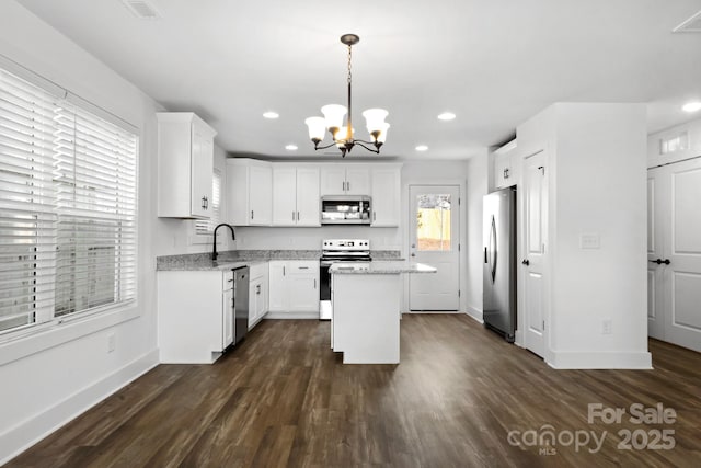 kitchen featuring sink, white cabinetry, a center island, pendant lighting, and stainless steel appliances