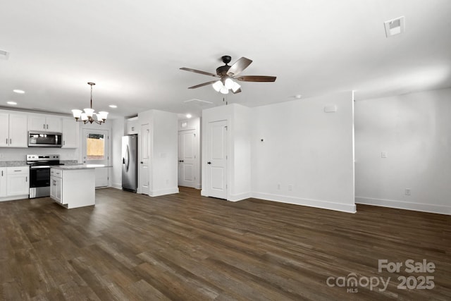 kitchen with ceiling fan with notable chandelier, appliances with stainless steel finishes, white cabinetry, dark hardwood / wood-style floors, and decorative light fixtures