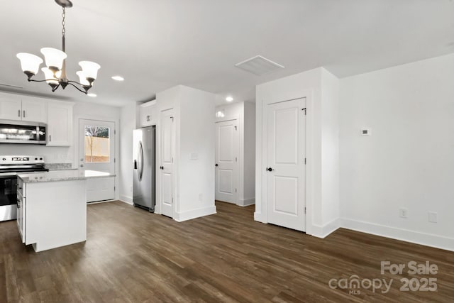 kitchen featuring decorative light fixtures, white cabinets, dark hardwood / wood-style flooring, light stone counters, and stainless steel appliances