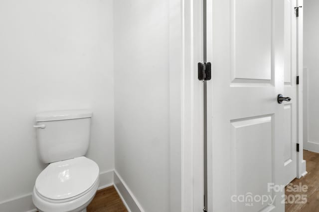 bathroom with toilet and hardwood / wood-style floors