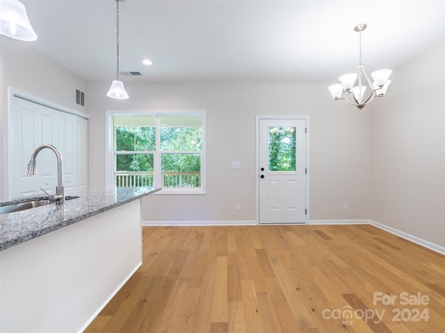 kitchen featuring pendant lighting, light hardwood / wood-style floors, and sink