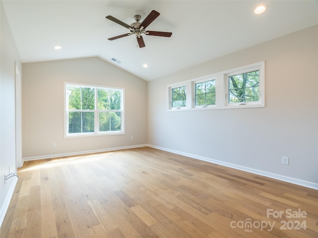 empty room with lofted ceiling, ceiling fan, and light hardwood / wood-style flooring