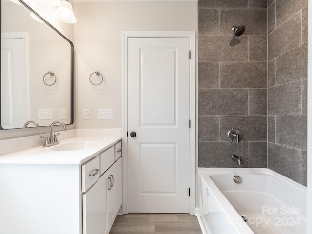 bathroom with tiled shower / bath and vanity