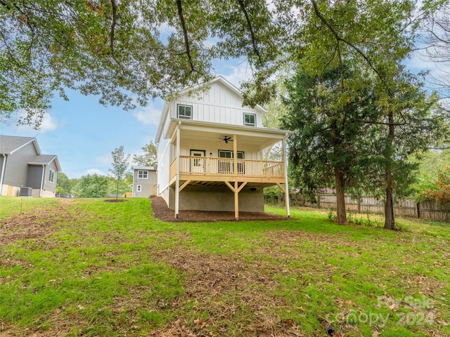 rear view of property with ceiling fan, cooling unit, and a lawn