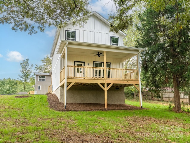 back of house with ceiling fan, a wooden deck, and a lawn