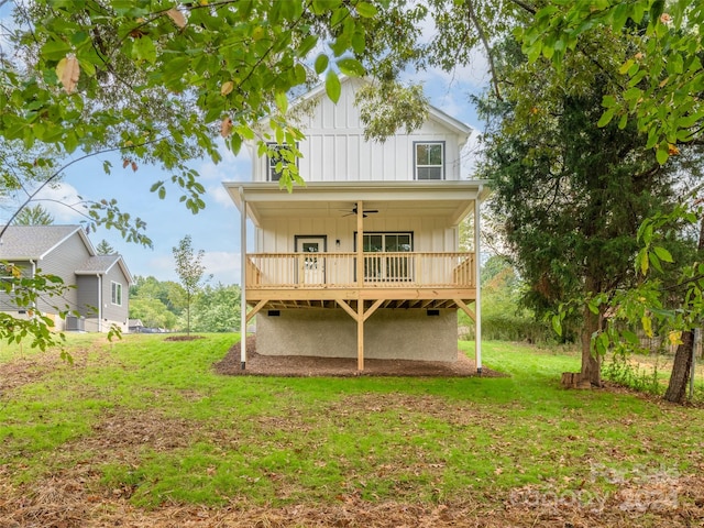 rear view of house with ceiling fan and a lawn