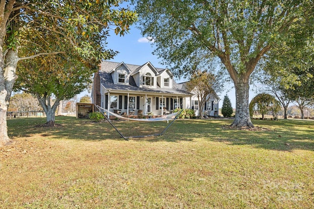 cape cod home featuring covered porch and a front lawn