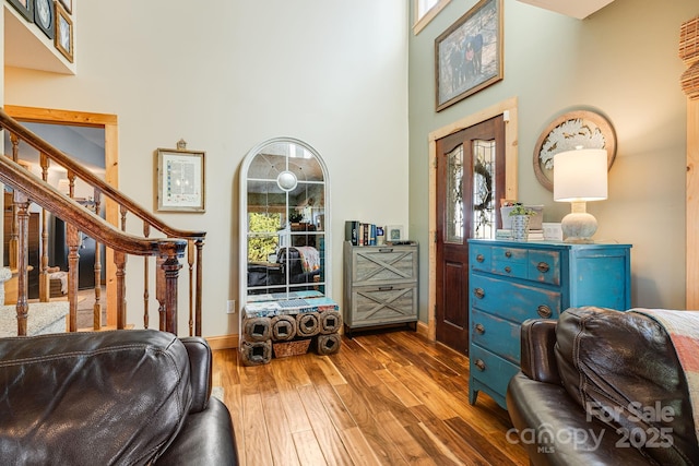 sitting room with a high ceiling, plenty of natural light, and light wood-type flooring