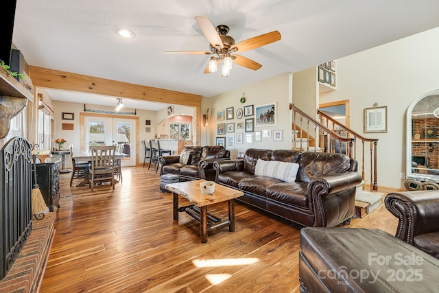 living room featuring ceiling fan, a fireplace, and hardwood / wood-style floors