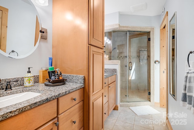 bathroom featuring tile patterned flooring, vanity, and an enclosed shower