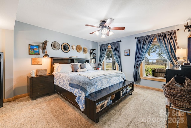 carpeted bedroom featuring ceiling fan and multiple windows