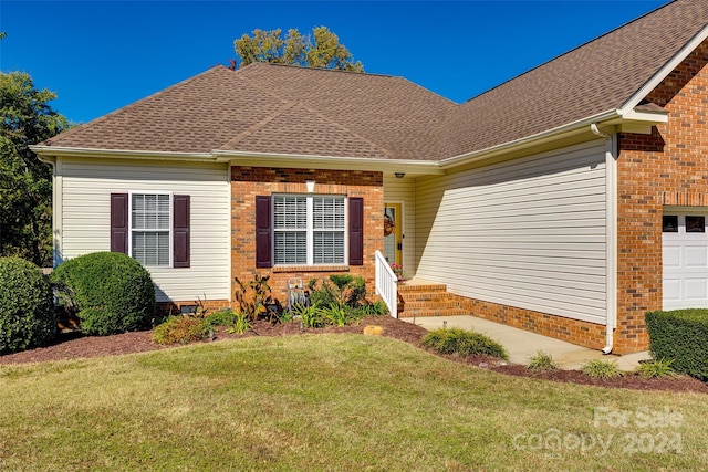 view of front of property featuring a front lawn and a garage