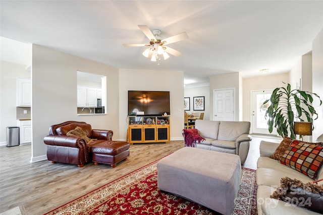 living room with light hardwood / wood-style flooring and ceiling fan