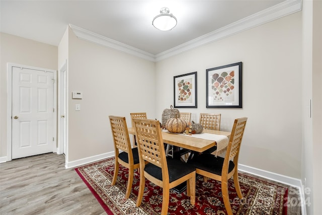 dining room featuring light hardwood / wood-style floors and crown molding