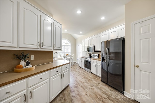 kitchen with sink, white cabinets, light hardwood / wood-style flooring, and stainless steel appliances