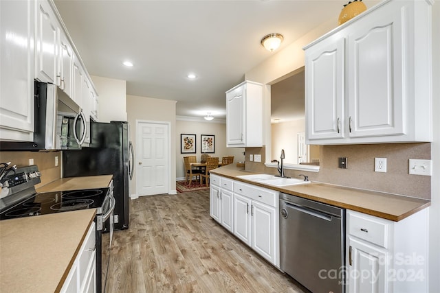 kitchen featuring decorative backsplash, white cabinets, sink, light hardwood / wood-style floors, and stainless steel appliances