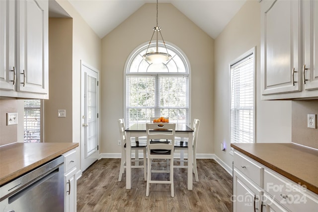 dining room with lofted ceiling, light hardwood / wood-style flooring, and a wealth of natural light