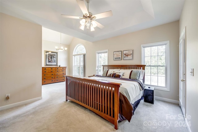 carpeted bedroom with ceiling fan with notable chandelier