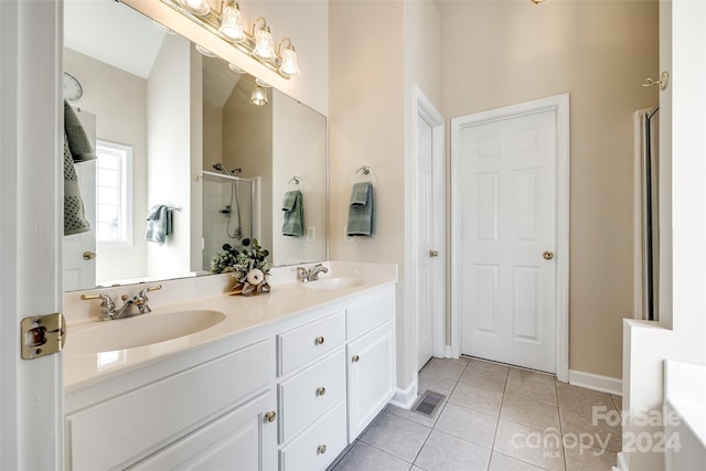 bathroom with a shower with door, tile patterned flooring, and vanity