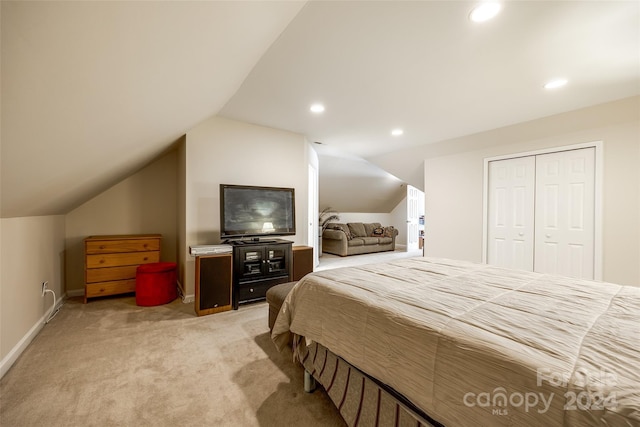 carpeted bedroom featuring vaulted ceiling and a closet