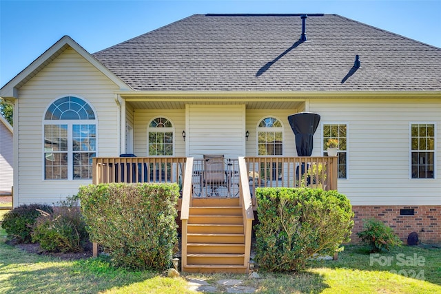 view of front of house with a wooden deck and a front lawn